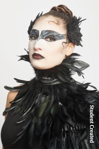 Image of a student model from a student photoshoot. She is dressed as the black swan with black feathers and intricate black makeup mask.
